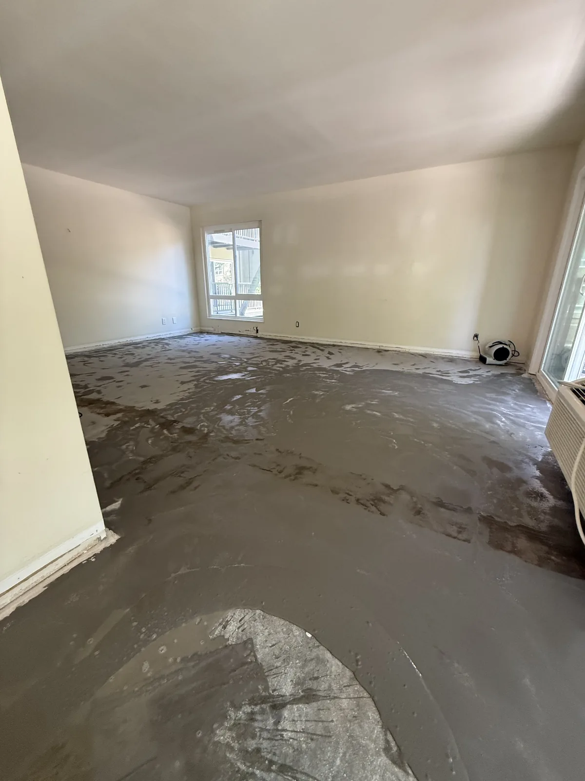 Exposed subfloor with patching across an Oak Creek apartment living area