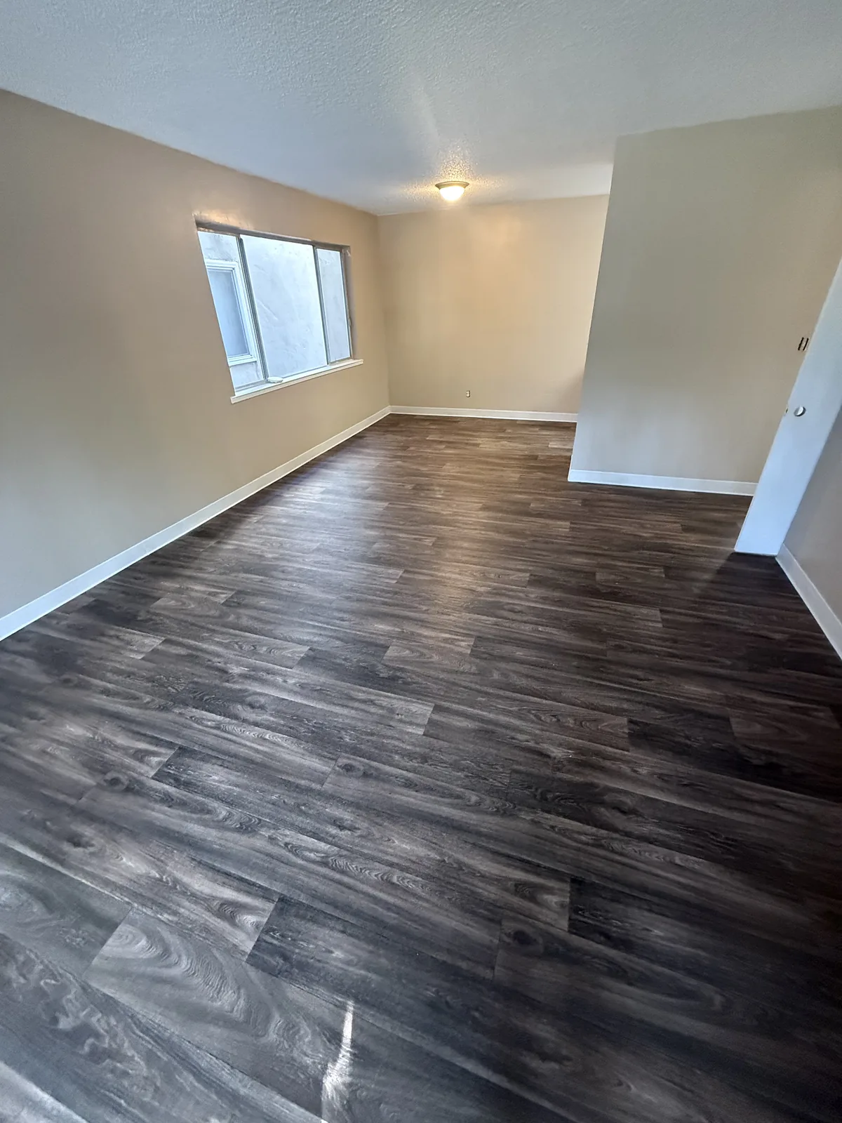 Completed dark wood-look flooring across a Woodland Park apartment living area